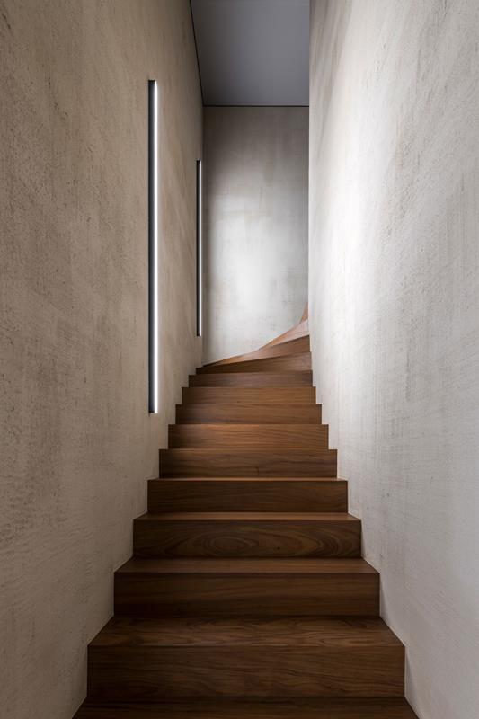 Lineare, wandbündige LED-Wandleuchten entlang einer Holztreppe